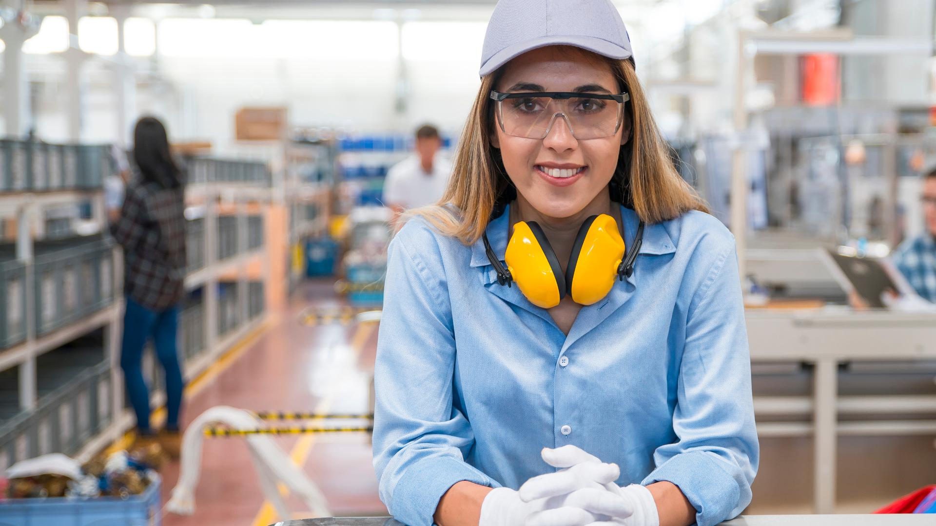 Fachkraft mit Schutzbrille und Gehörschutz in einer industriellen Arbeitsumgebung